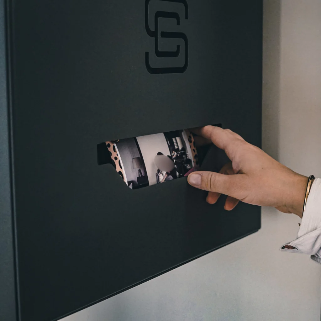 Main récupérant une photo imprimée instantanément depuis la borne photobooth Ouistibox, idéale pour repartir avec un souvenir personnalisé de son événement.